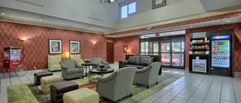 A lobby with seating, a vending machine, and a door to the marketplace.