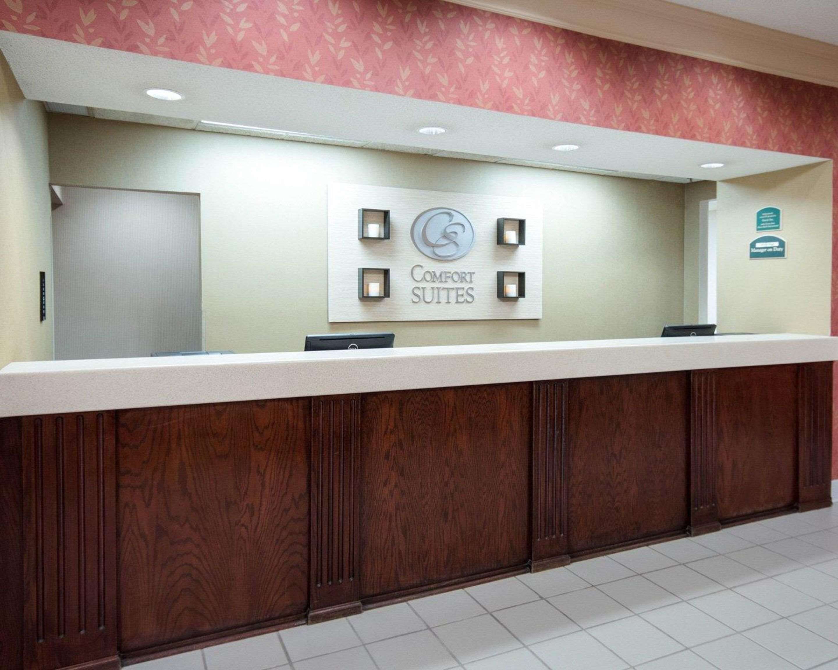A reception desk with a sign for 'Comfort Suites' and a 'Manager on Duty' sign.