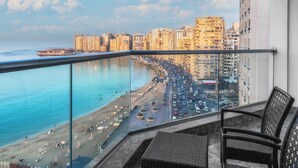 A balcony with a view of a beach and cityscape. - Hilton Alexandria Corniche (Alexandria)