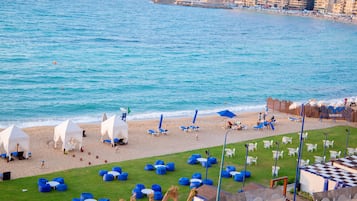 Praia particular, areia branca, espreguiçadeiras, guarda-sóis