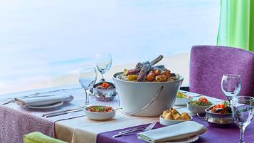 Un tavolo da pranzo apparecchiato con diversi piatti, bicchieri e posate, con vista su un panorama suggestivo.