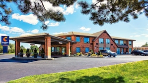Un hotel Comfort Inn con un área exterior cubierta, edificio de ladrillo y estacionamiento.
