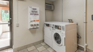 A laundry room with a washing machine and a sign listing soap, bleach, and softeners. - Red Roof Inn PLUS+ Wilmington - Newark (Newark)