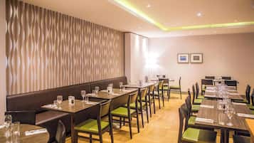 A restaurant with multiple dining tables and booths, equipped with glasses and cutlery.