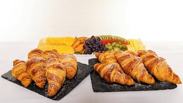 A table with croissants and a fruit platter.