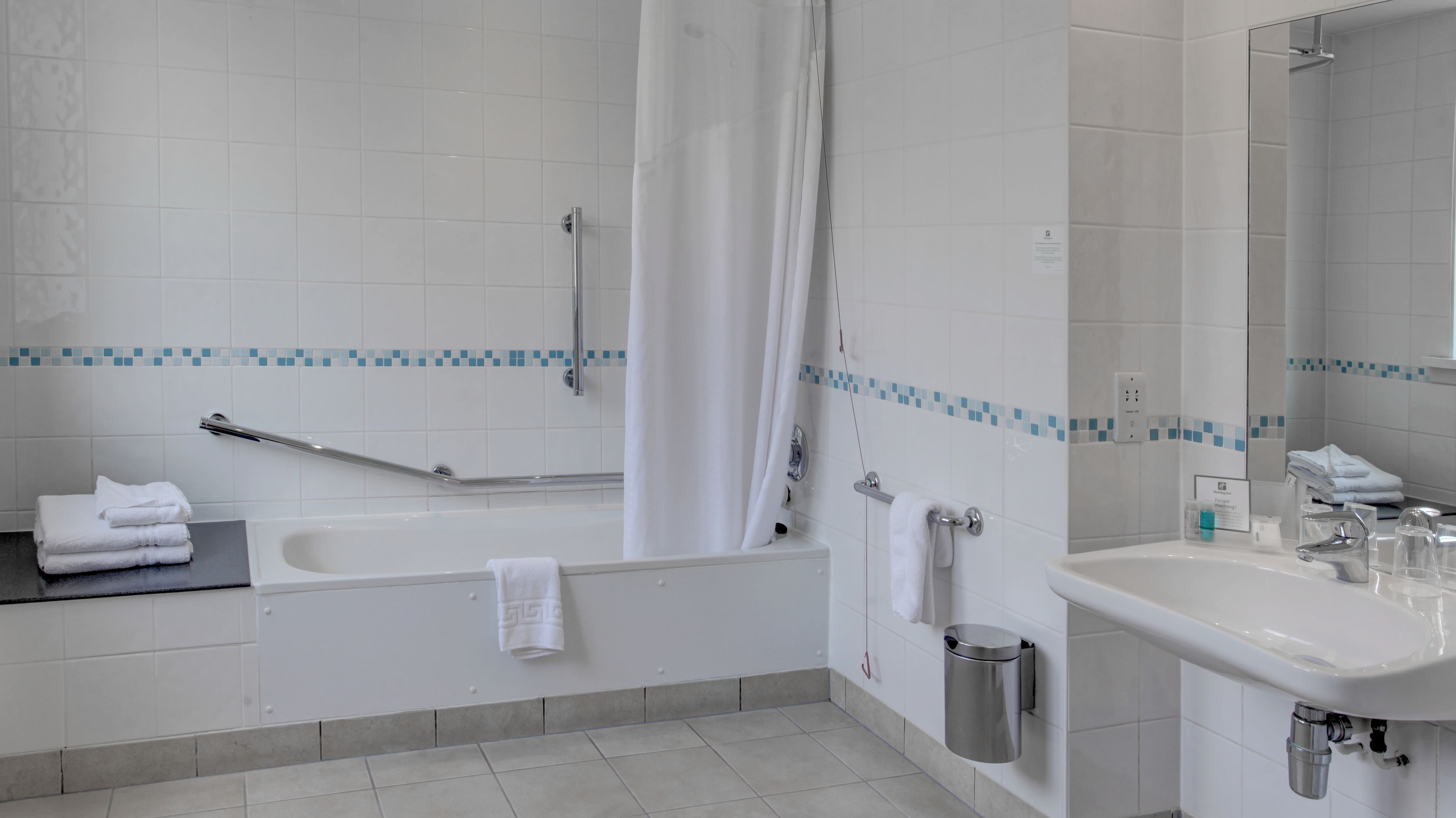 A modern bathroom with a bathtub, a sink, and a shower area.