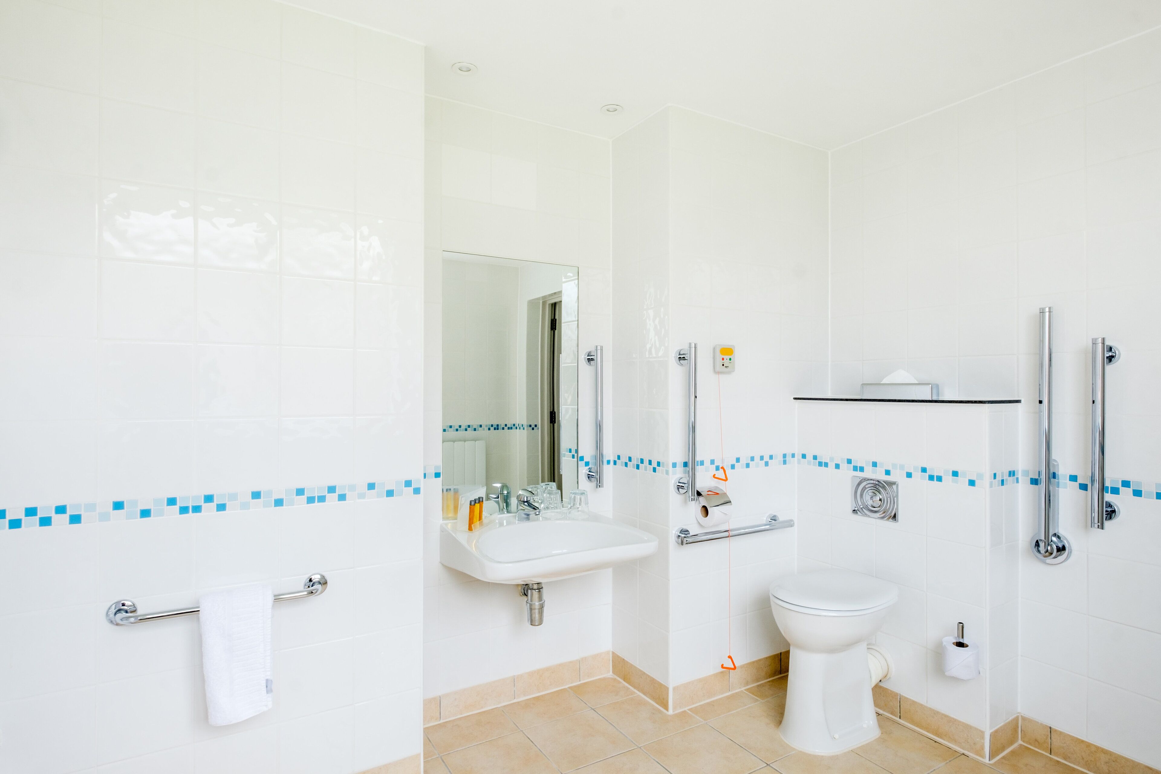 Une salle de bain moderne équipée d’un lavabo, de toilettes et d’une douche.
