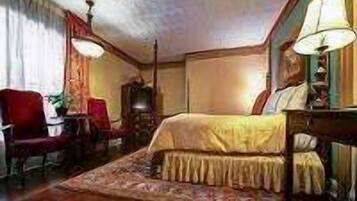 A traditional room with a bed, a desk, and a chair.
