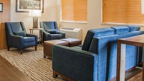 A hotel room with a sofa set, two armchairs, a small table, and a rug. - Comfort Inn Marshalltown South (Marshalltown)