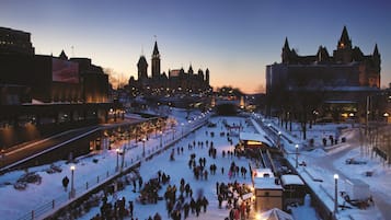 Una piazza innevata con persone che passeggiano, circondata da edifici dall'architettura storica.