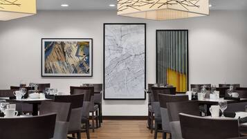 A dining area with tables set for service, a large map of Ottawa on the wall, and modern lighting fixtures.