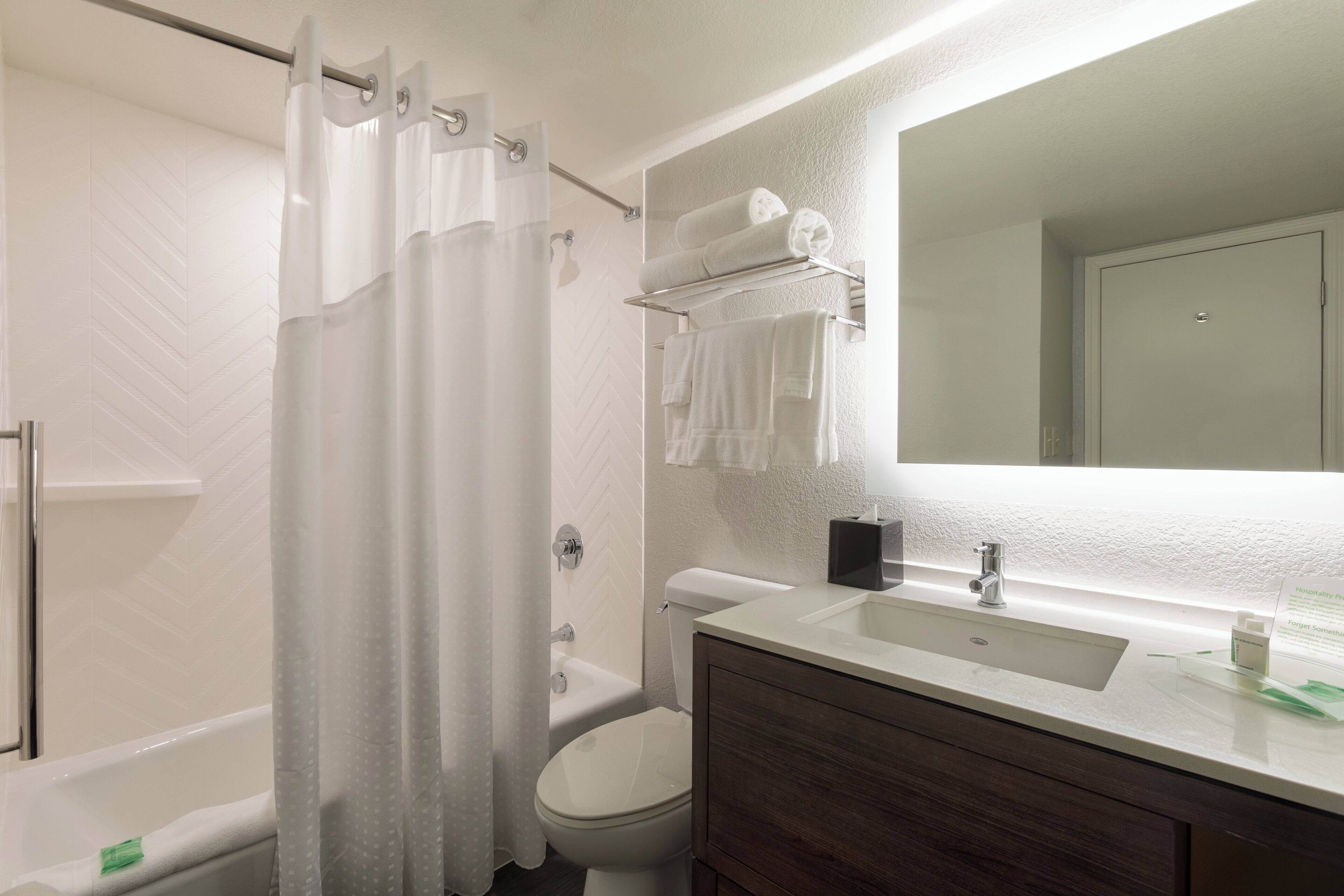 A modern bathroom with a shower, toilet, and sink.