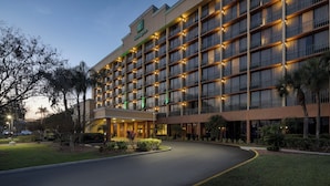 Een groot hotel met meerdere verdiepingen, een goed verlichte ingang en een aangelegde oprit.