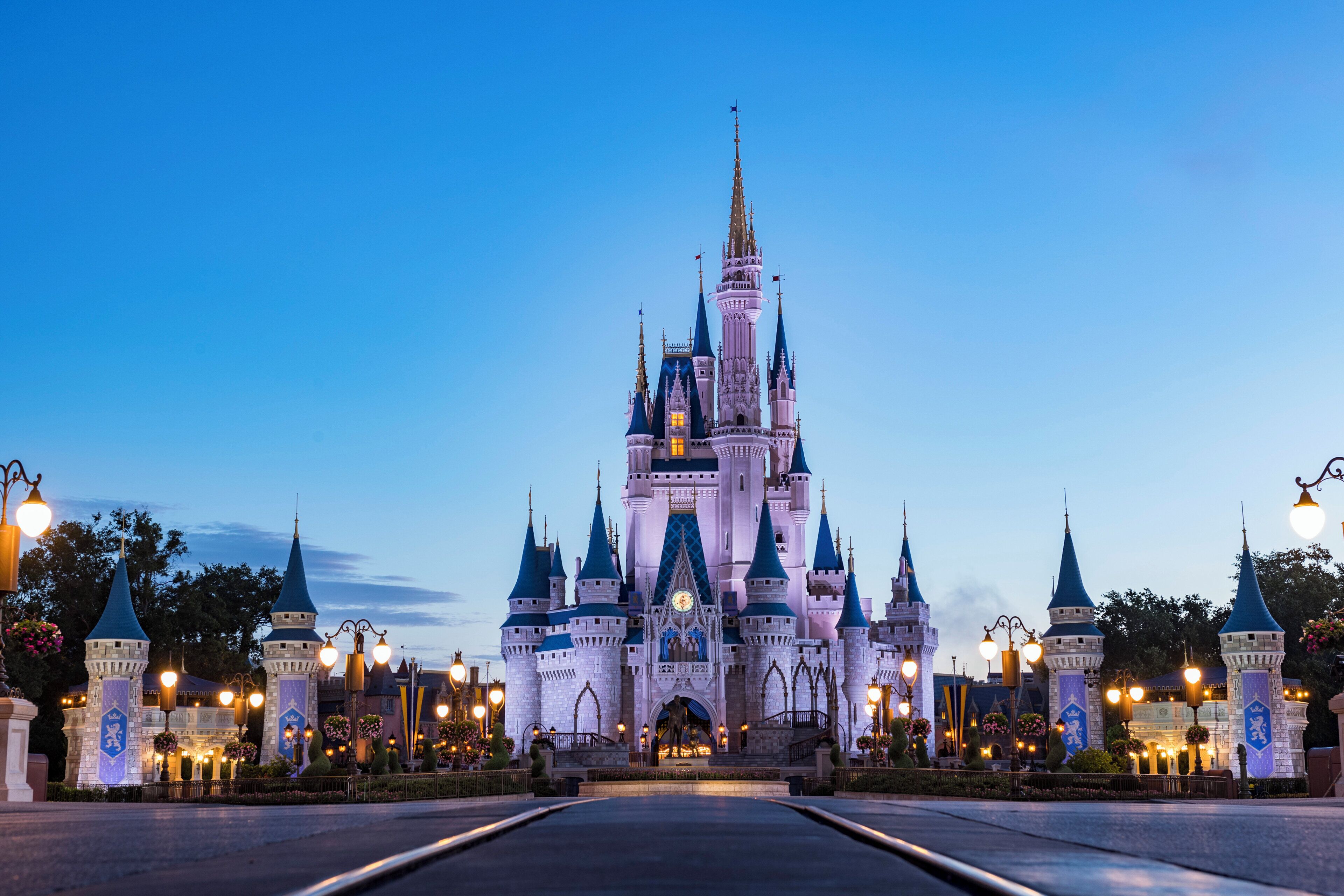A castle-like structure with multiple towers and a central spire, surrounded by well-lit street lamps and decorative elements.