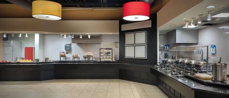 Una cocina moderna con una isla central, equipada con diversos electrodomésticos y una disposición tipo bufé.