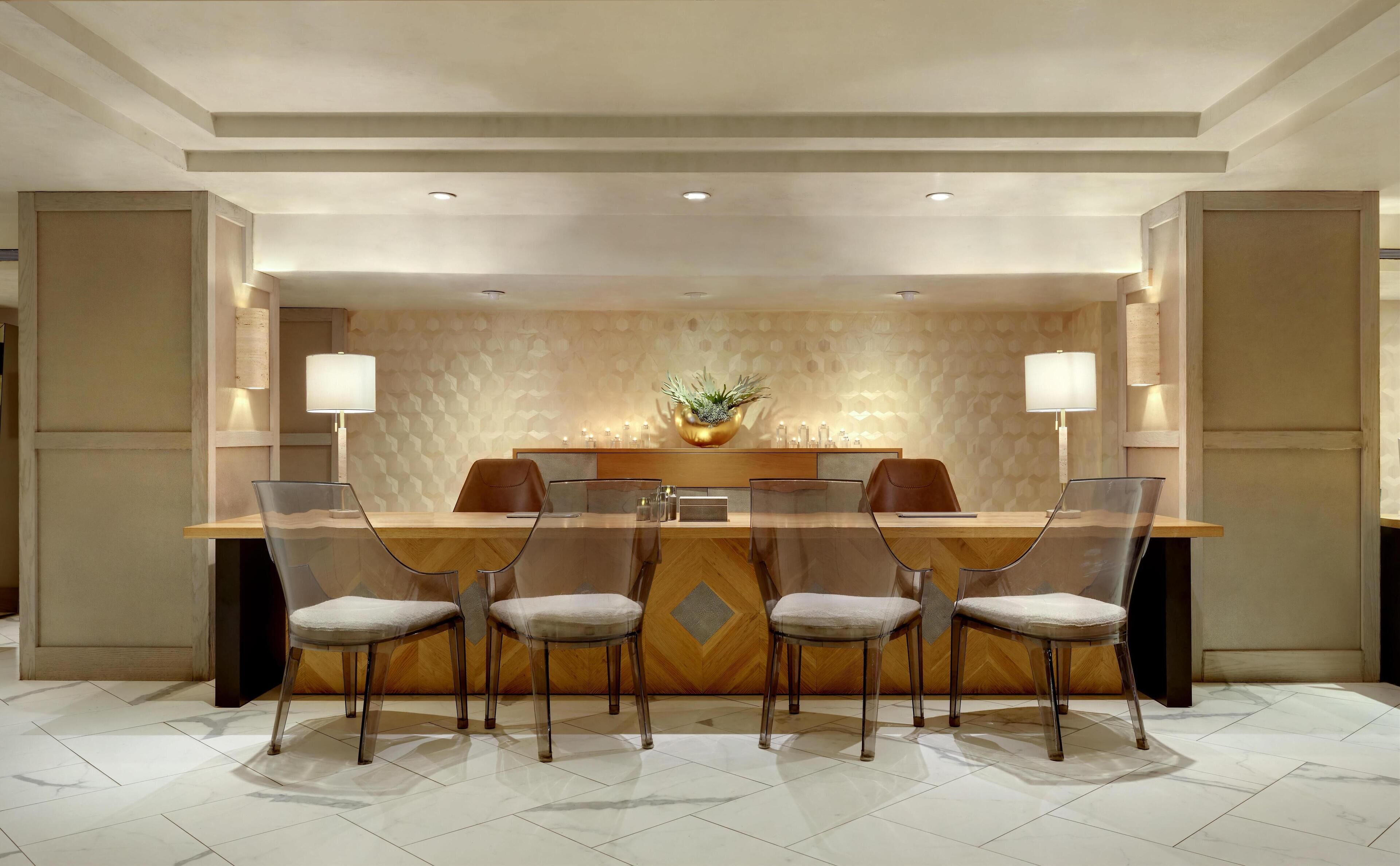 A modern dining area with a central island, clear chairs, and ambient lighting.