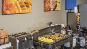 A buffet setup with various food items, a toaster, and a coffee machine. - Comfort Inn Kenora (Kenora)