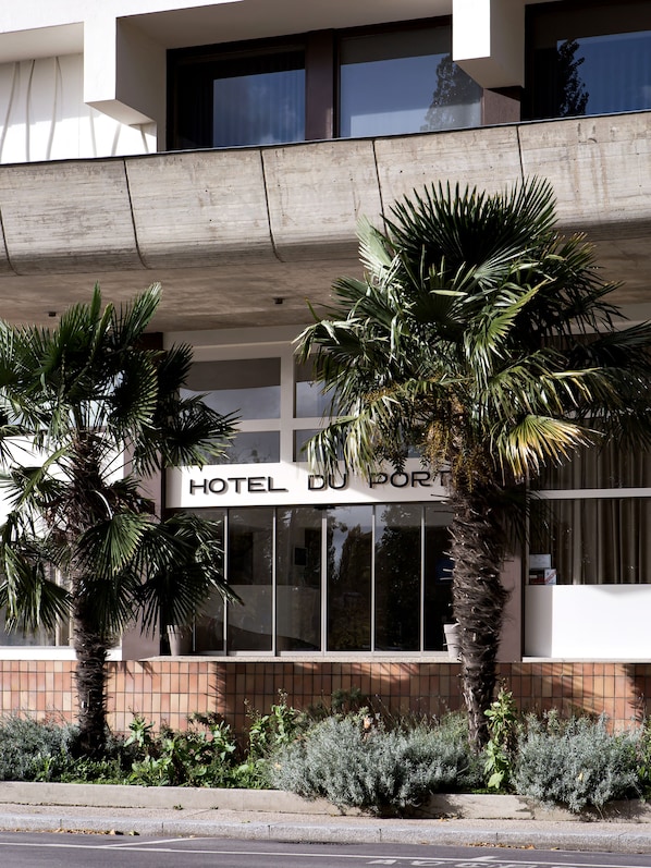 Un immeuble sur lequel on peut lire l’inscription « HÔTEL DU PORT ».