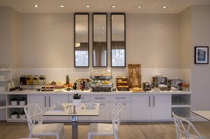 Una cocina moderna con armarios blancos, una barra desayunadora y diversos alimentos.