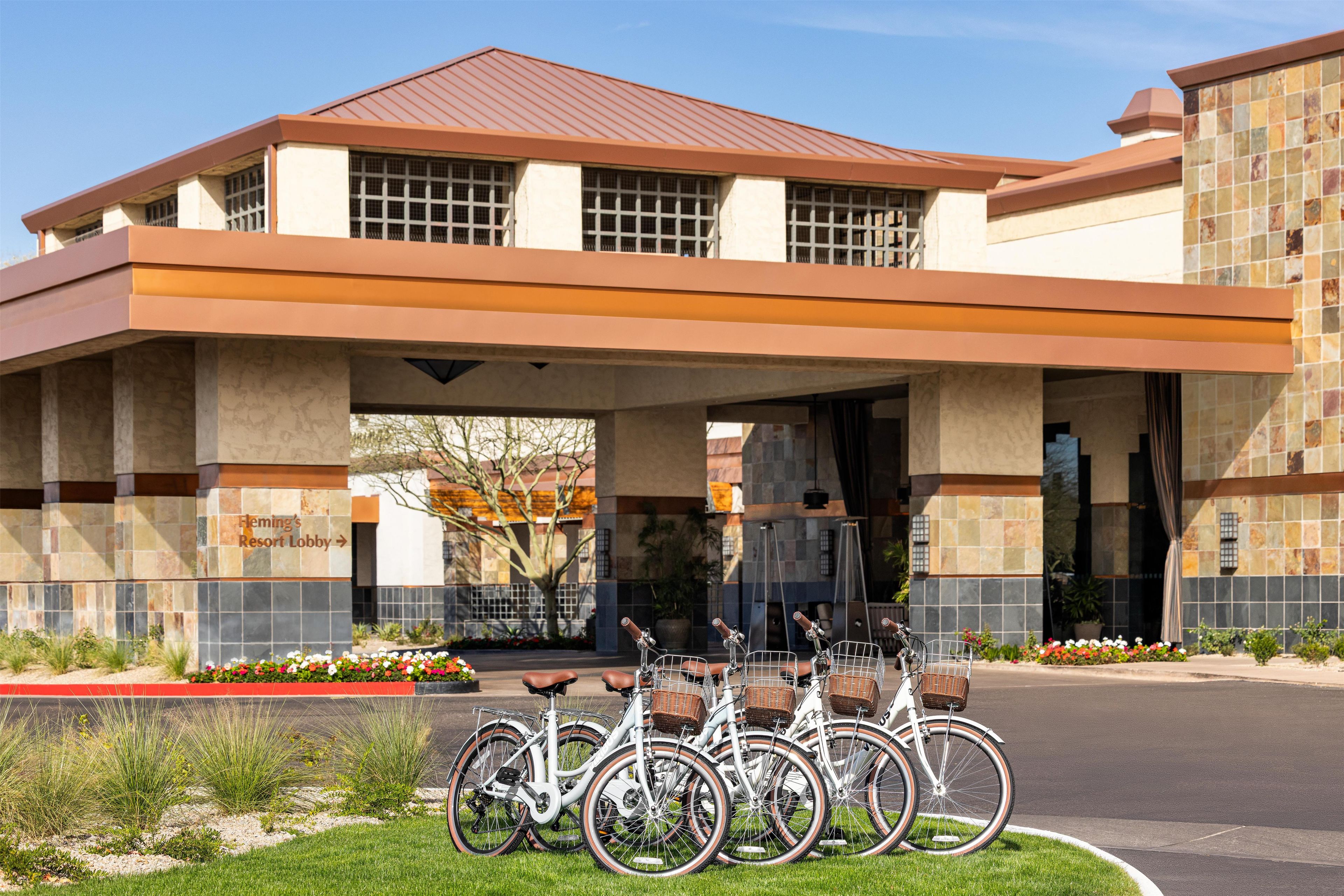 A building with a sign reading 'Flemings Resort Lobby' and a row of bicycles parked in front.