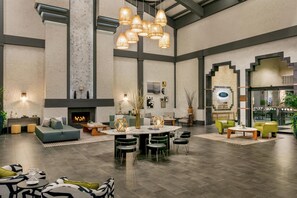 A spacious living area with a fireplace, a round dining table surrounded by chairs, and a seating area with sofas and armchairs. - Hilton Scottsdale Resort & Villas (Scottsdale)