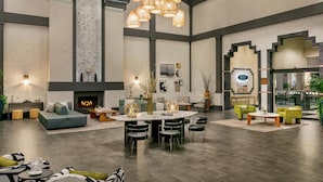 A spacious living area with a fireplace, a round dining table surrounded by chairs, and a seating area with sofas and armchairs. - Hilton Scottsdale Resort & Villas (Scottsdale)