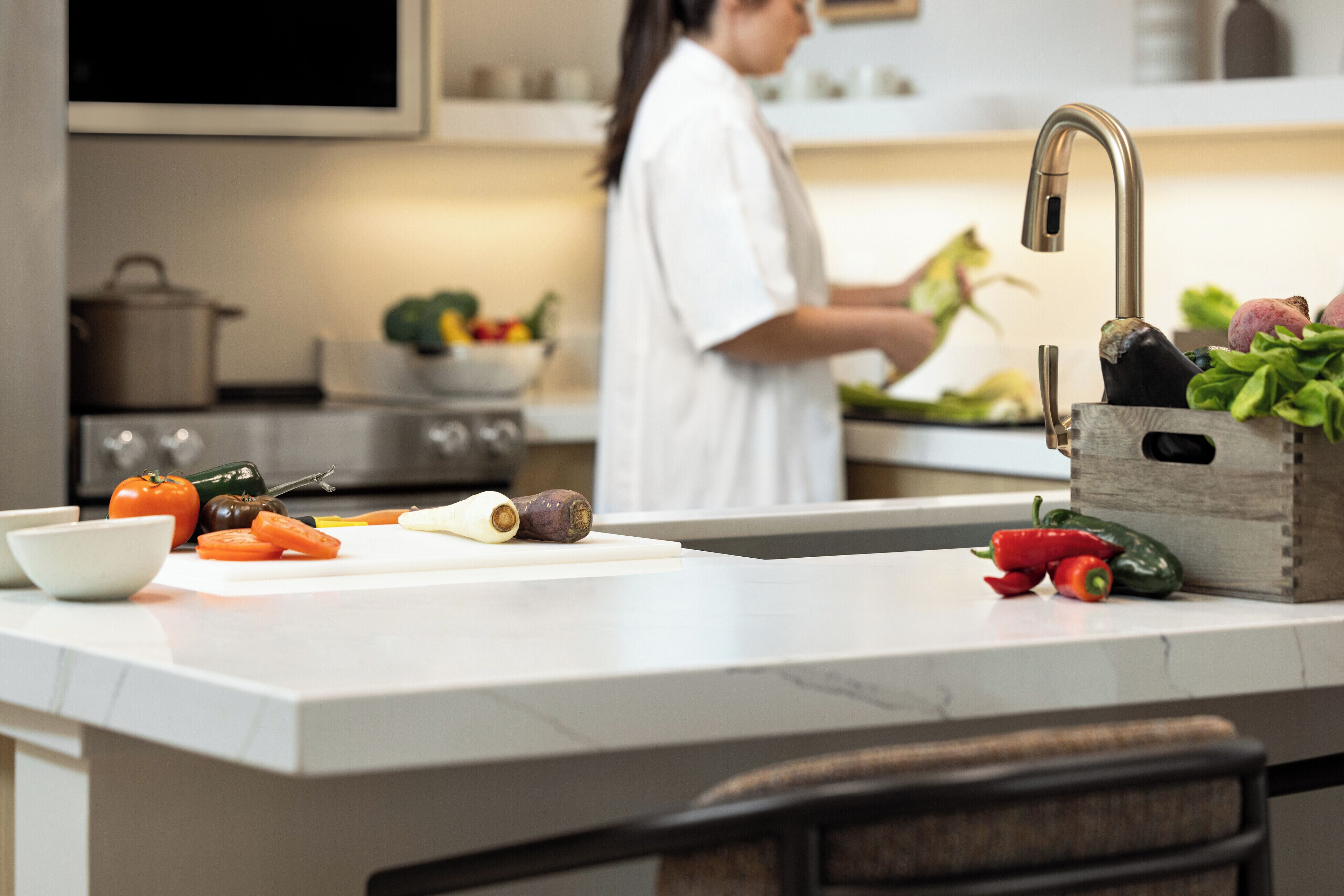 A kitchen with a central island, a sink, and a stove.