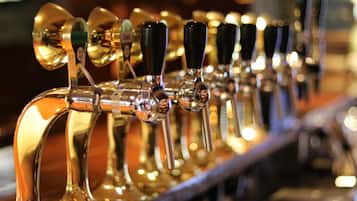 A row of beer taps with handles, some labeled with beer brands.