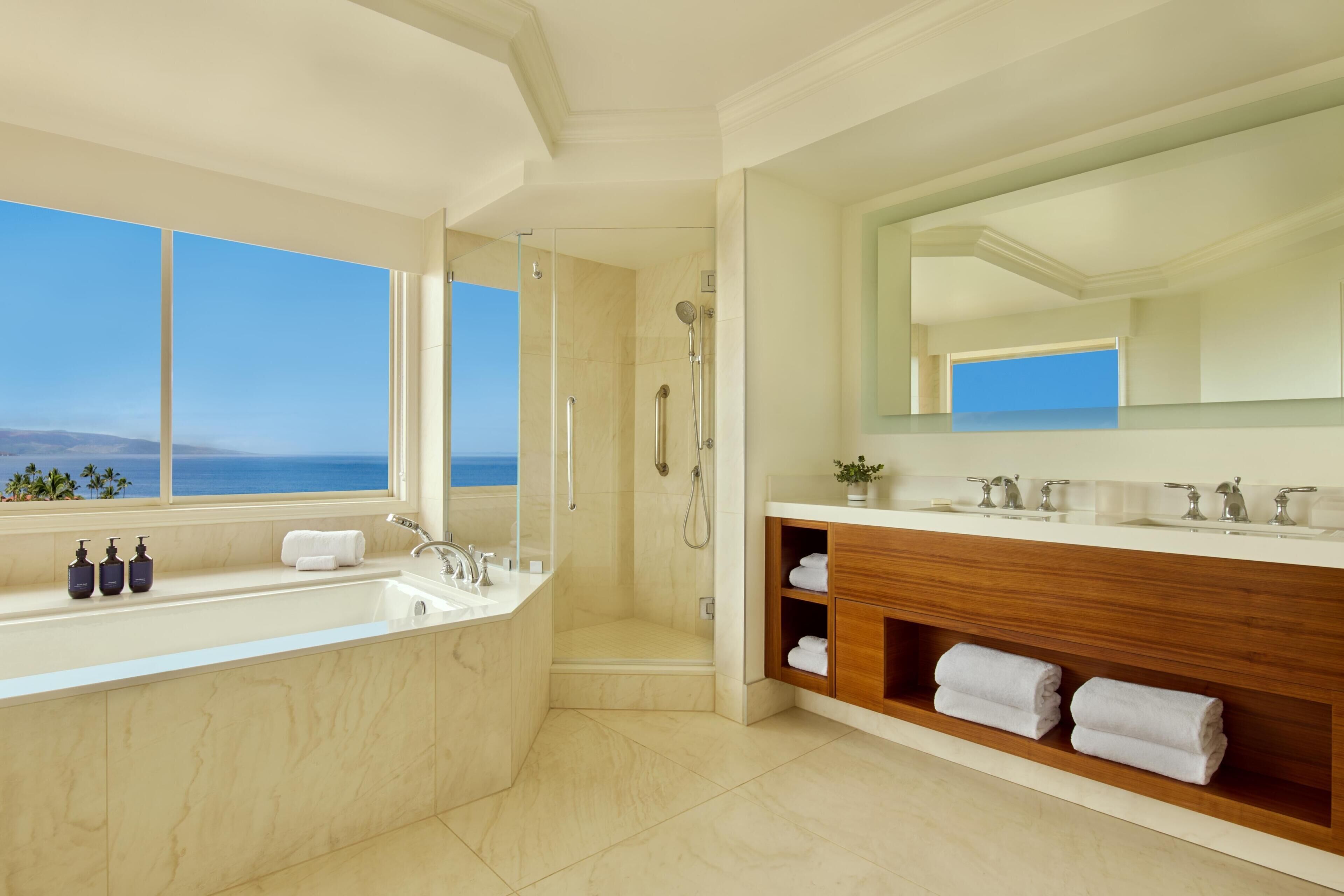 A modern bathroom with a bathtub, shower, and vanity.