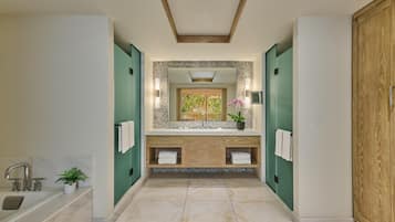 A modern bathroom with a vanity, a bathtub, and a large mirror.