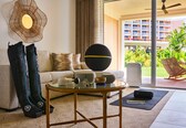 A modern living room with a sofa, coffee table, and exercise mat.