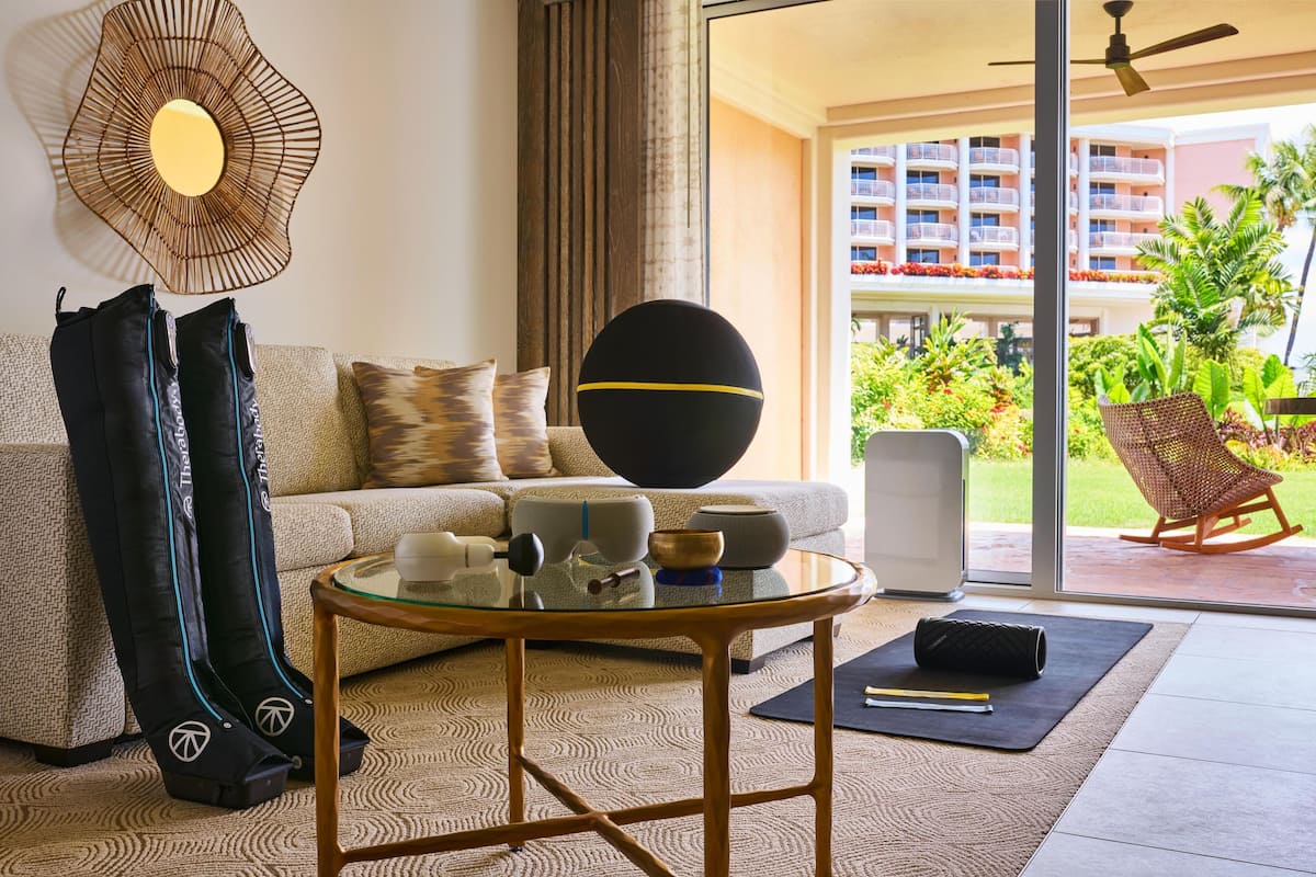A modern living room with a sofa, coffee table, and exercise mat.