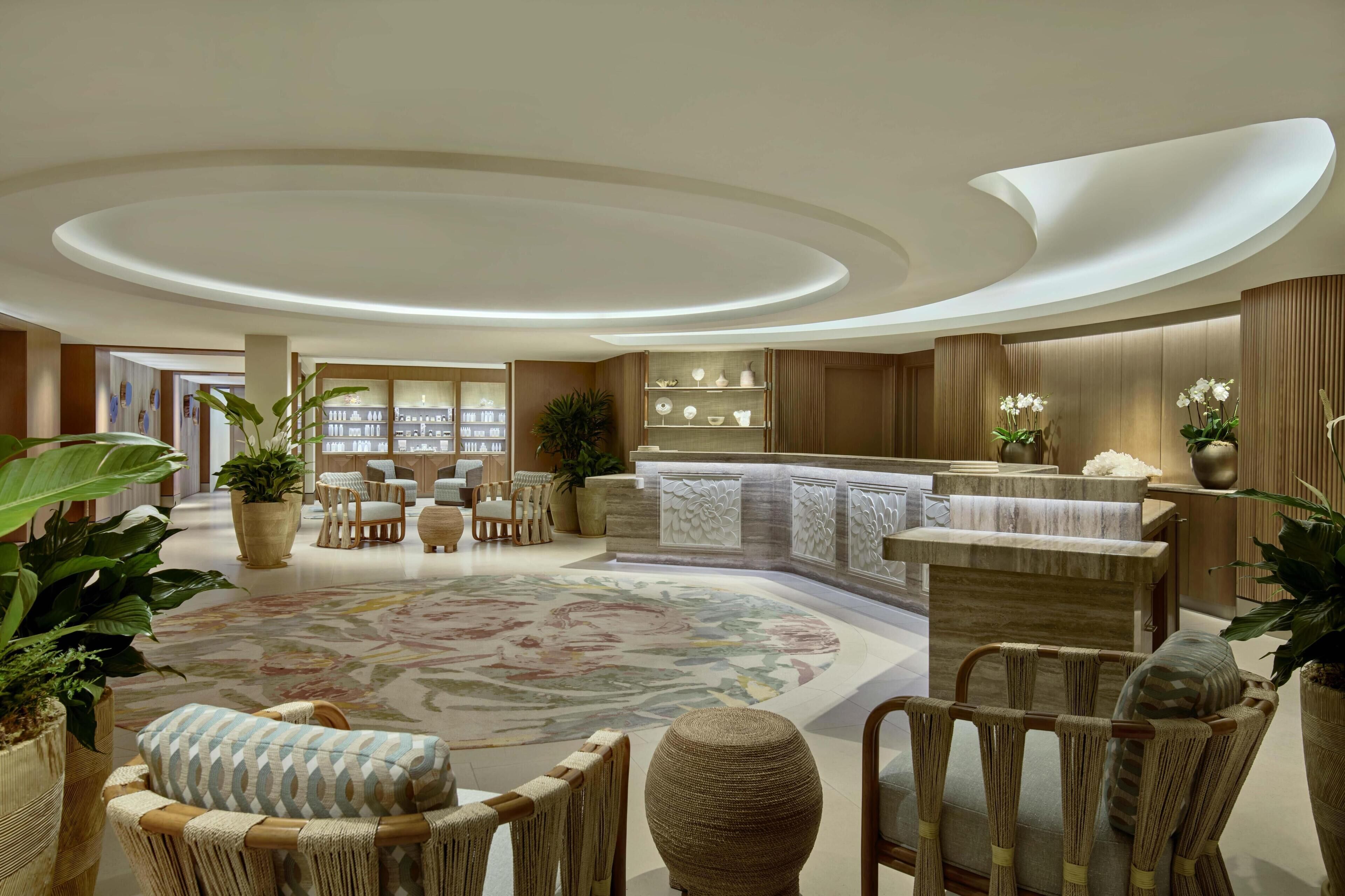 A spacious lobby with a central seating area, a reception desk, and a large, patterned carpet.