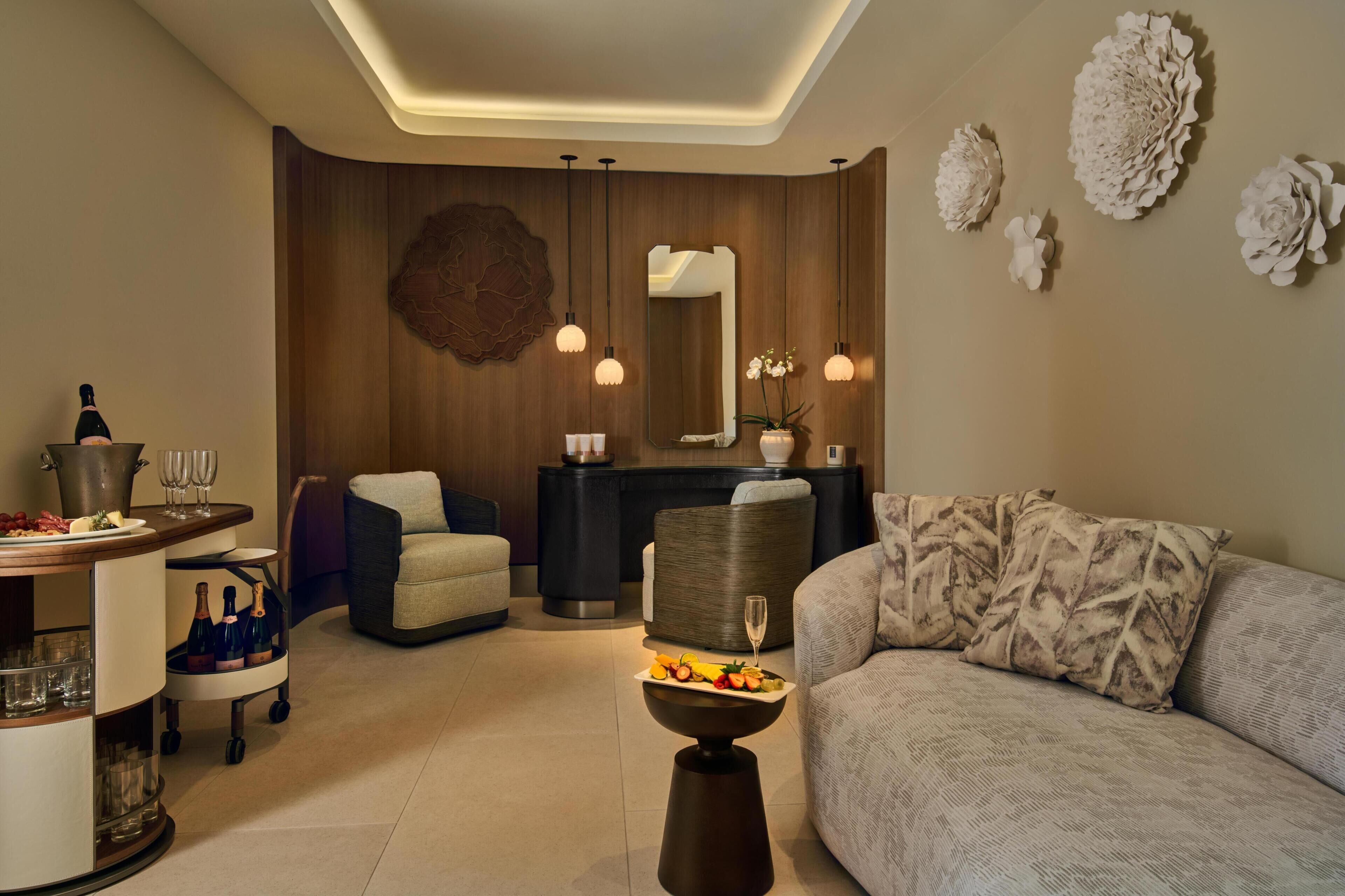 A modern living room with a sofa, a dining area with a table and chairs, a bar area with a counter, and decorative wall art.