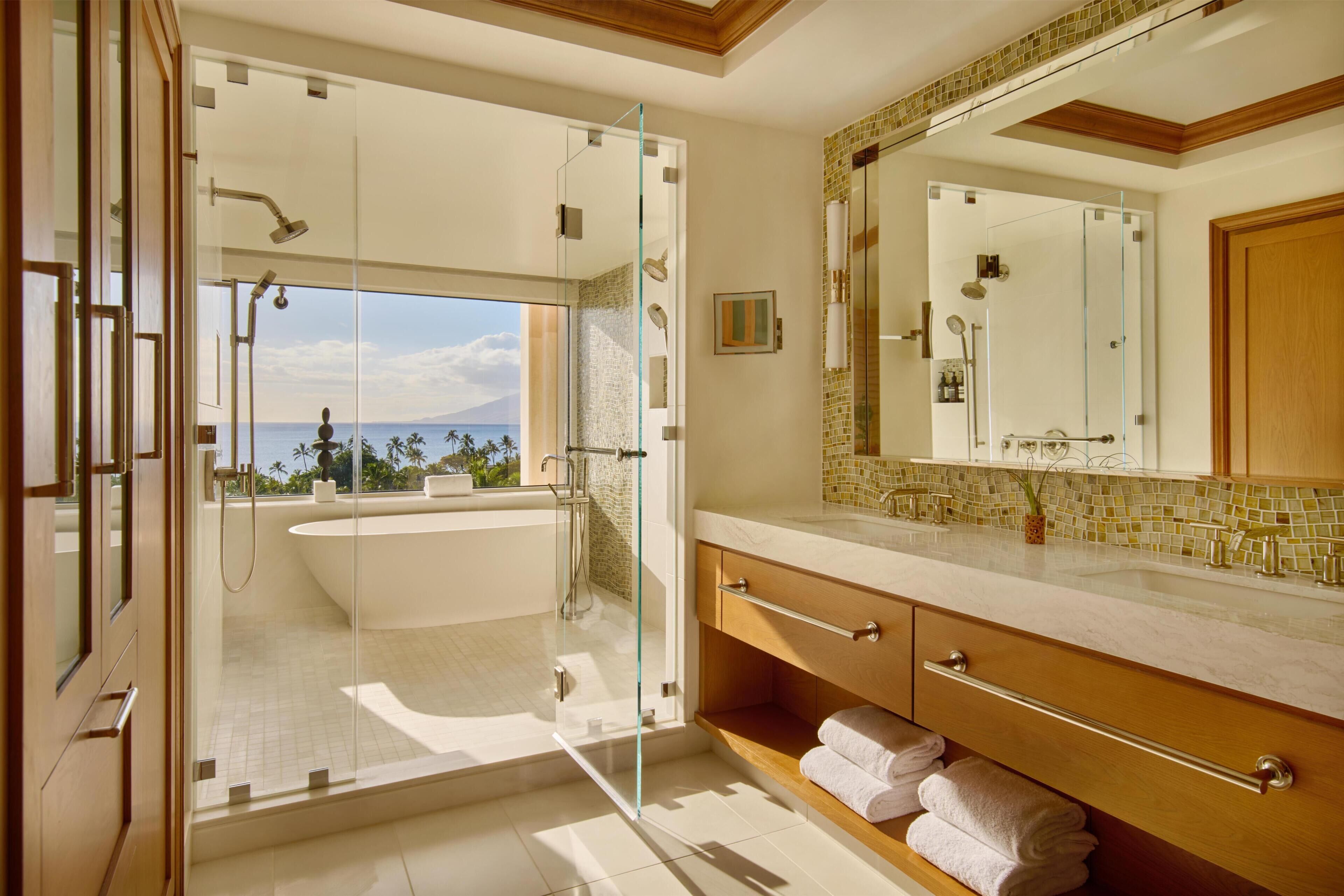 A modern bathroom with a glass-enclosed shower, a bathtub, and a vanity with a large mirror.