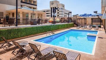 Relax by the rectangular pool surrounded by lounge chairs and tables.