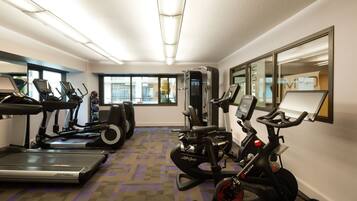 A gym with treadmills, elliptical machines, and a weight machine.
