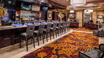 A bar area with multiple bar stations, chairs, and a patterned carpet.