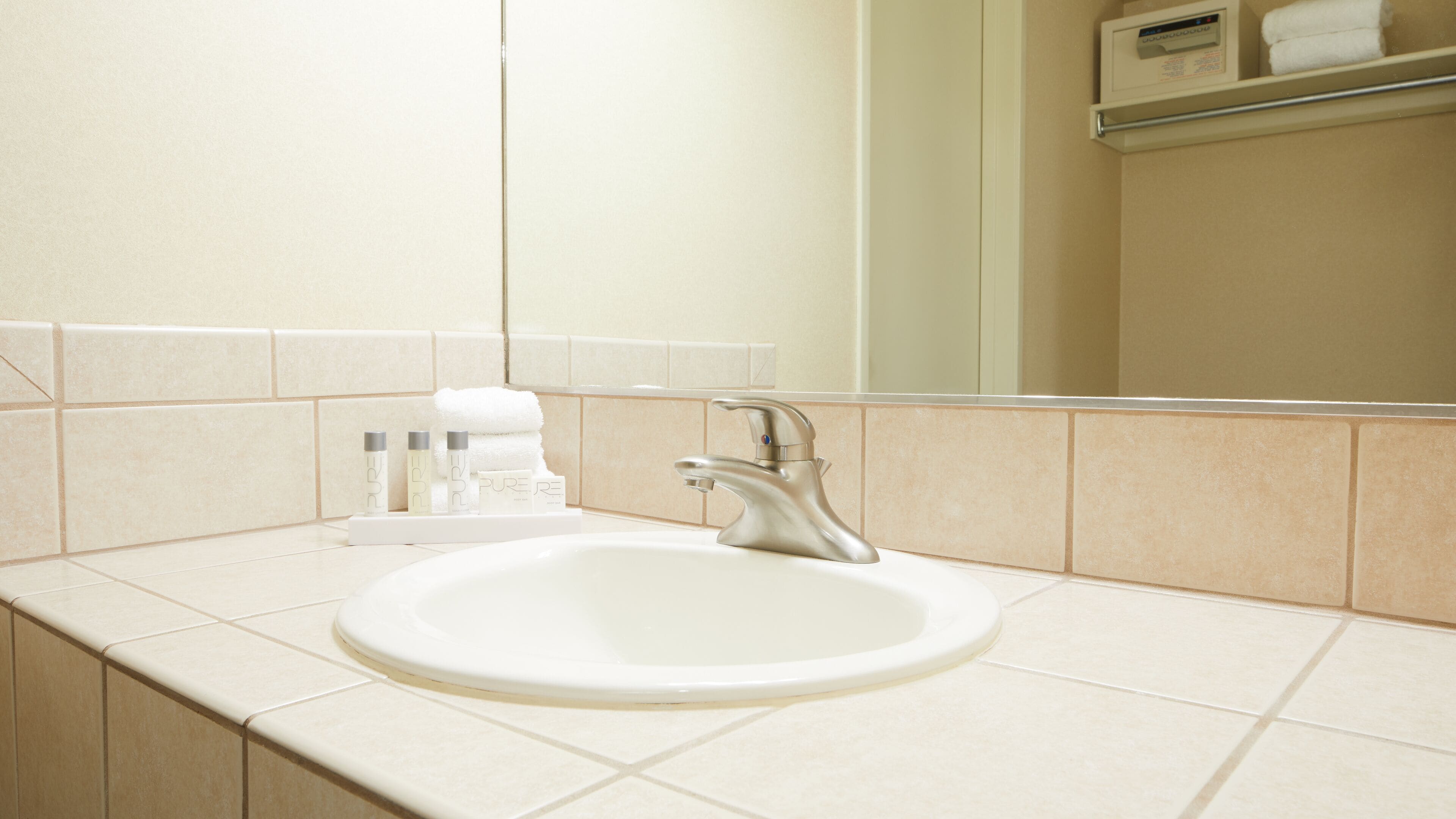 A bathroom with a white sink, a mirror, and a towel rack.