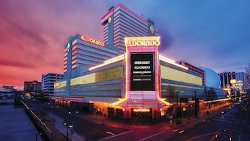 A hotel with a prominent marquee sign, multiple floors, and a large screen advertising the hotel.
