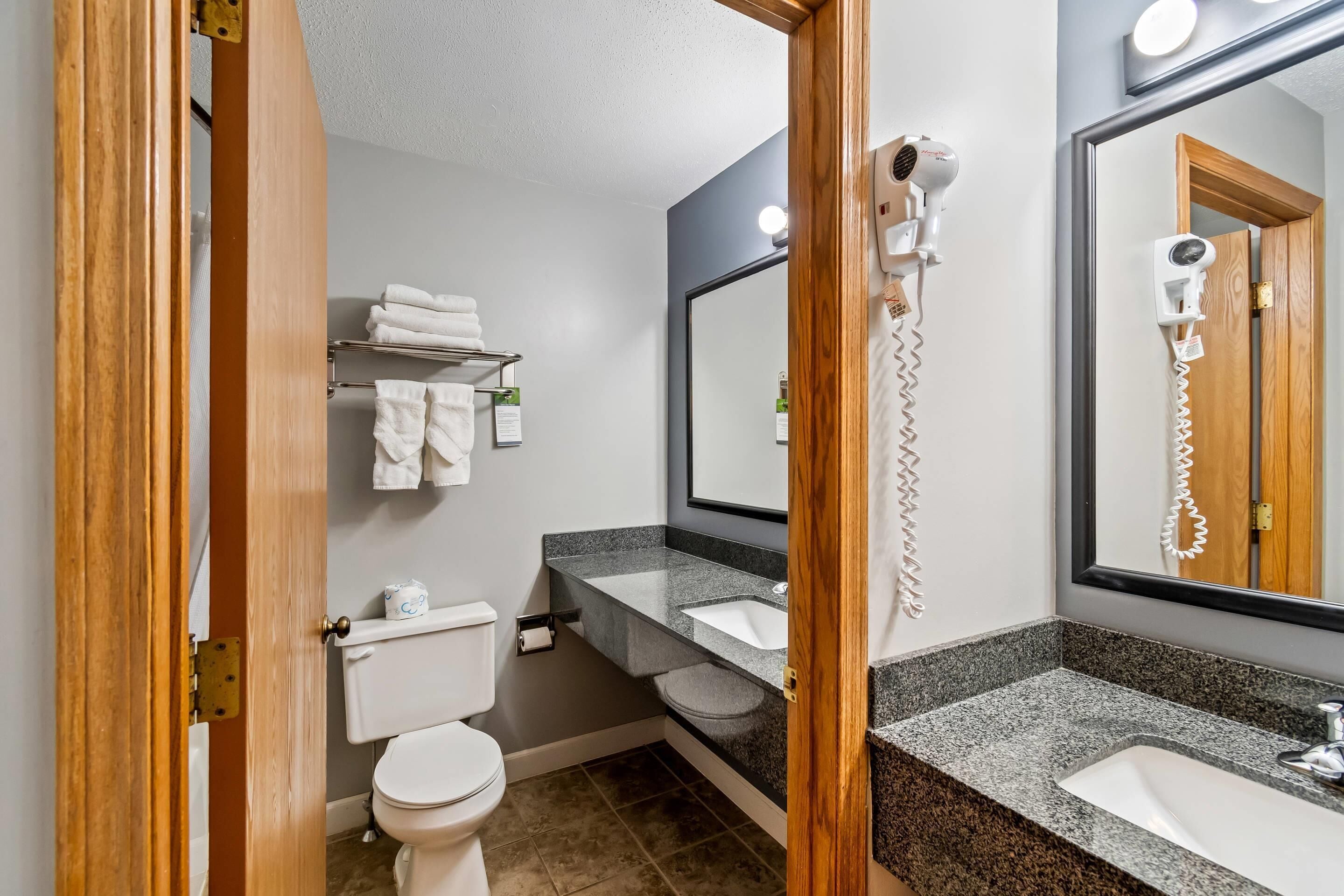 Een badkamer met toilet, wastafel en handdoekhouder.