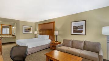 Una habitación de hotel con cama, sofá, escritorio y silla.