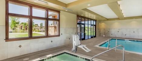 A swimming pool area with a hot tub, a sunroof, and a view of the outdoors.