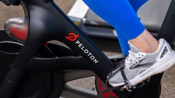 A stationary bike with a red knob and the Peloton logo.