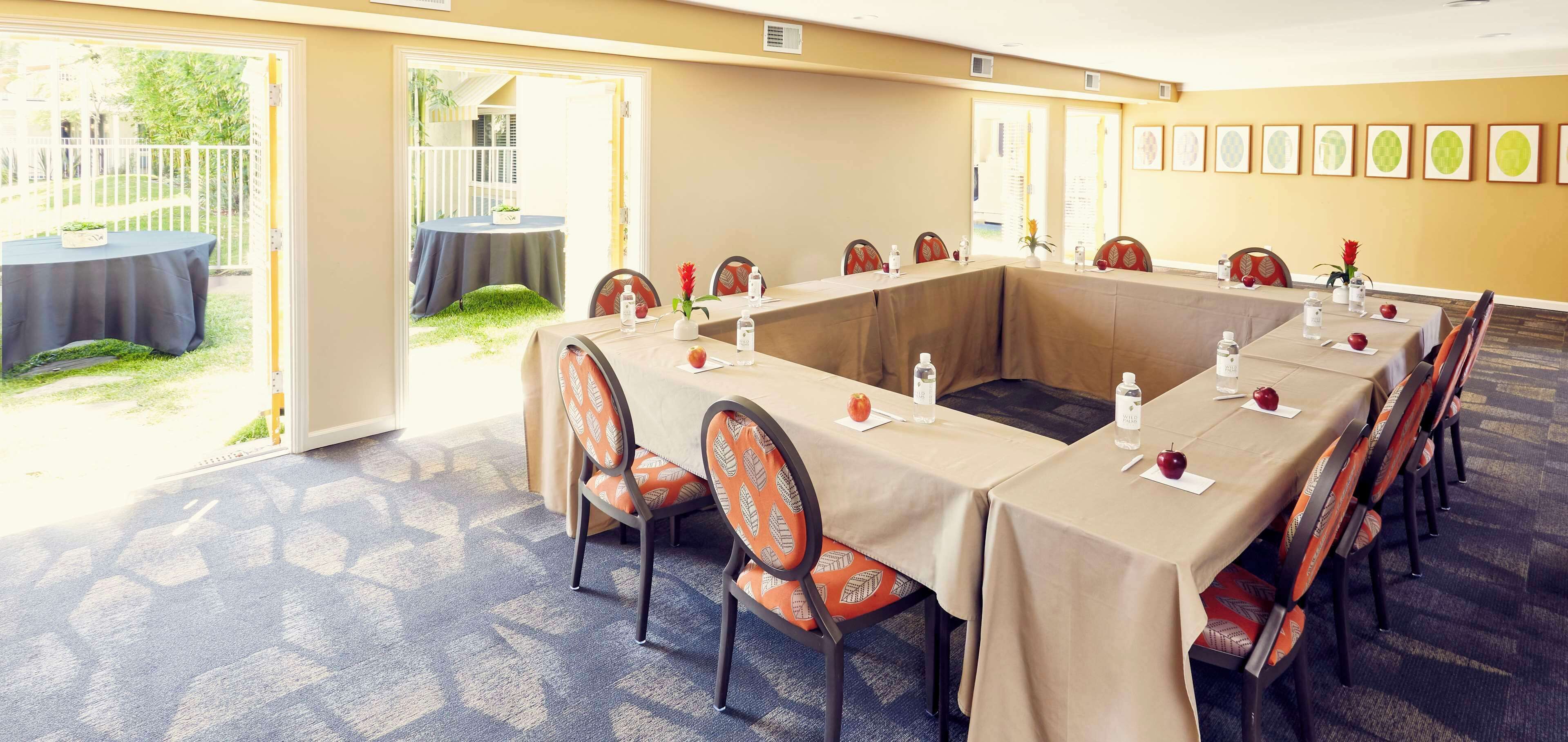 A conference room with a long table, chairs, and a view of the outdoors.