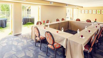 Un salón de conferencias con una larga mesa, sillas y vistas al exterior.