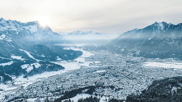 En vidsträckt utsikt över en snötäckt bergsstad med en flod som rinner genom den.