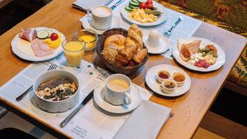 Ein reichhaltiges Frühstücksbuffet mit verschiedenen Speisen, darunter Eier, Brot und Obst.