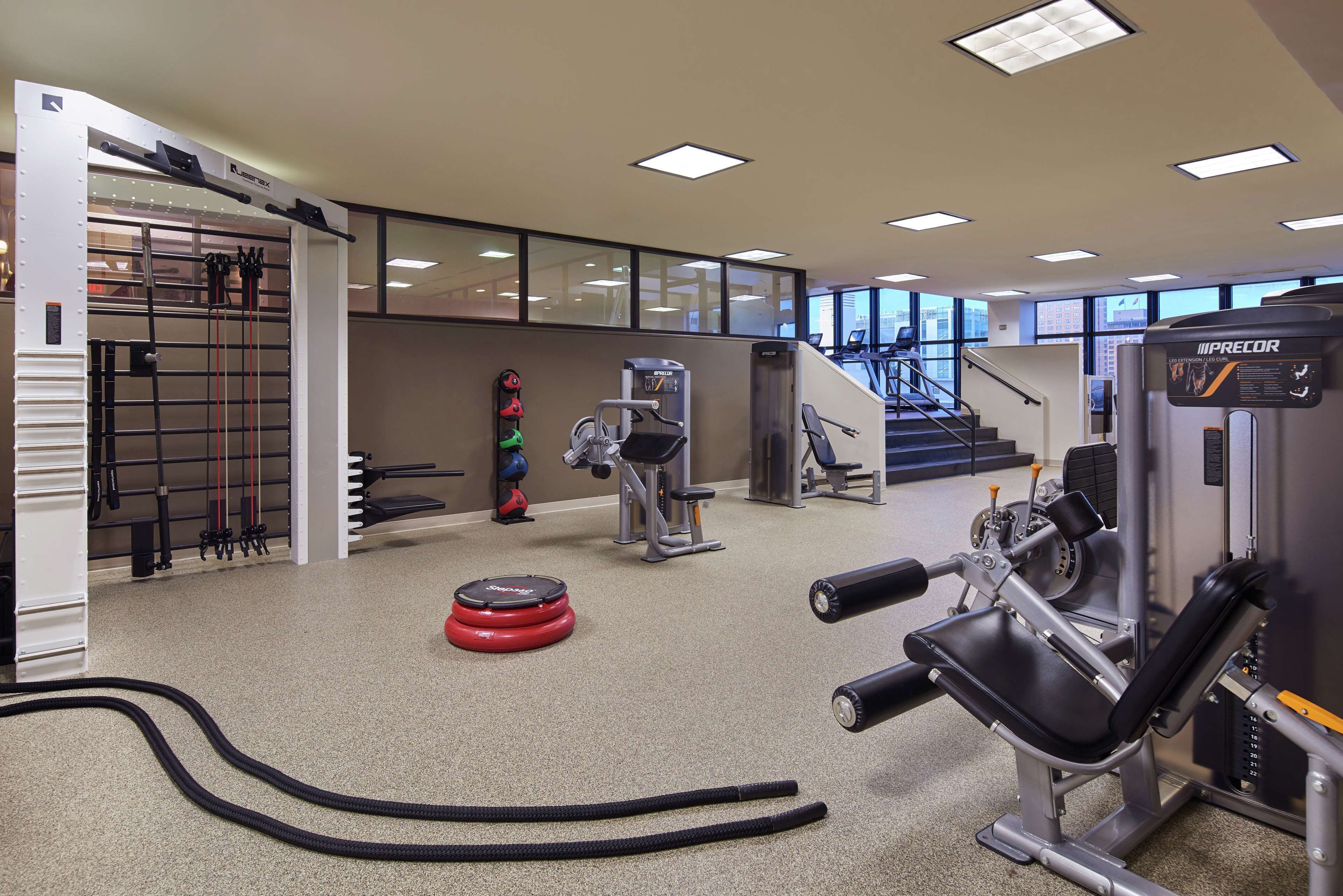 A gym with various exercise equipment, a pull-up bar, and a stair machine.