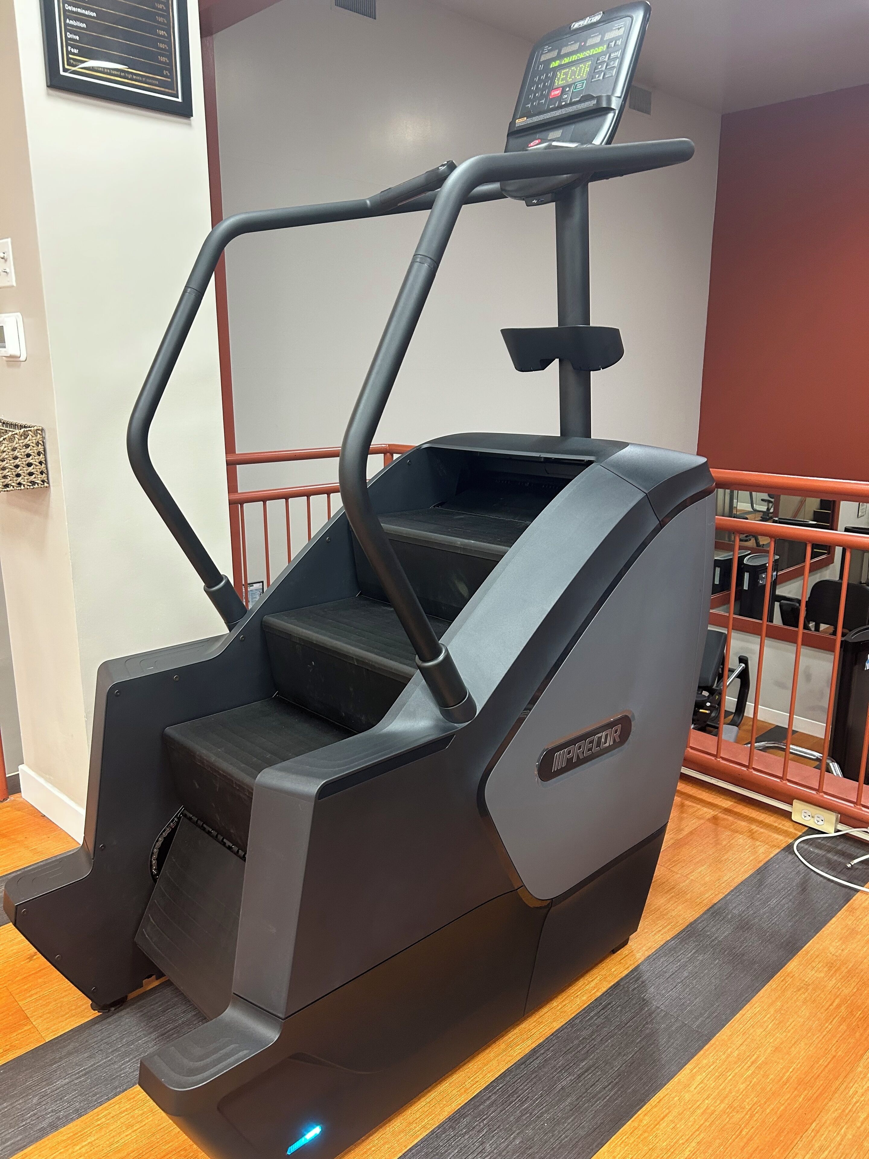A stationary exercise bike with a digital display, a step platform, and a control panel.